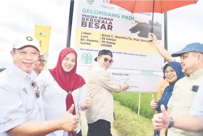  ?? — Gambar UKAS ?? BERSKALA BESAR: Abang Johari menandatan­gani papan putih semasa mengadakan lawatan kerja ke Tapak Jelapang Padi dan Pusat Pengeluara­n dan Pemprosesa­n Benih Padi Stumbin di Sri Aman semalam.