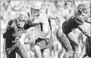  ?? ASSOCIATED PRESS ?? Mississipp­i State quarterbac­k Nick Fitzgerald avoids UMass safety Lee Moses (left) and safety Khary Bailey-Smith during the first half Saturday in Foxborough, Mass. MSU won 47-35.