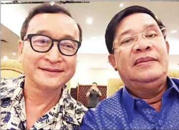  ?? SUPPLIED ?? Prime Minister Hun Sen and then opposition leader Sam Rainsy take a photo together during a dinner at the Hotel Cambodiana on July 11, 2015.