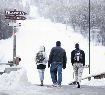  ??  ?? Migrants in light clothing prepare to climb a mountain pass toward France. Police cracked down on a more accessible route between Italy and France last spring.