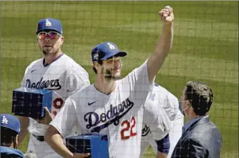  ?? Luis Sinco Los Angeles Times ?? DODGERS pitcher Clayton Kershaw shows the fans at Dodger Stadium his 2020 World Series ring in a ceremony prior to the team’s 1-0 home-opener win. Fans were allowed back for the first time since 2019.