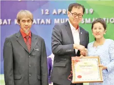  ??  ?? Poon (centre) presenting the ‘Tokoh Guru’ Award to Chong while Sharif Mahada looks on.