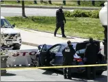  ?? J. SCOTT APPLEWHITE — THE ASSOCIATED PRESS ?? U.S. Capitol Police officers stand near a car that crashed into a barrier on Capitol Hill in Washington, Friday.