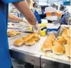  ?? JOE BURBANK/ ORLANDO SENTINEL ?? Line workers assemble cheese sliders by the hundreds during lunch hour at the White Castle. The Orlando location of the fast food chain is on pace to set a single-year record for the highest sales in the company in their first 200 days open.