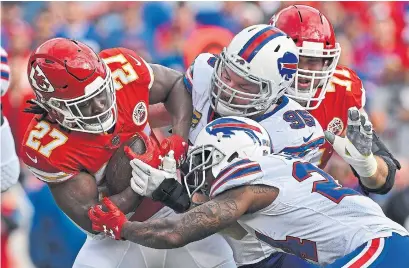  ?? PETER G. AIKEN GETTY IMAGES ?? Bills defenders Leonard Johnson and Kyle Williams tackle Chiefs running back Kareem Hunt on Monday night in Kansas City.