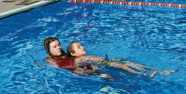  ?? Foto: Bernd Hohlen ?? Jennifer Kaiser von der Ortsgruppe Augsburg-West der Wasserwach­t zeigt an Jakob Peghini, wie Menschen in Notsituati­onen gerettet werden. Wenige Minuten später muss im selben Becken tatsächlic­h ein Junge vor dem Ertrinken gerettet werden.