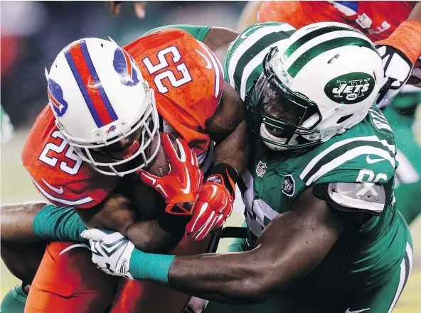  ?? — AP FILES ?? Buffalo Bills running back LeSean McCoy, left, is hit by New York Jets defensive end Muhammad Wilkerson during NFL action last November. The players are sporting the Nike Color Rush alternate uniforms that will be in vogue for Thursday night games this...