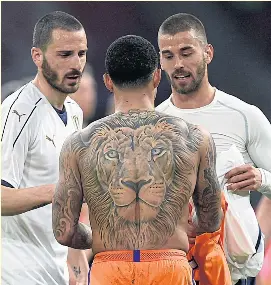  ??  ?? The Netherland’s Memphis Depay, centre, swaps shirts with Italy’s Leonardo Spinazzola, right, after a friendly match on Tuesday.