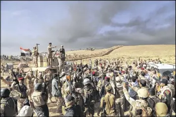  ?? AP ?? Iraqi army soldiers raise their weapons in celebratio­n on the outskirts of Mosul, Iraq, Thursday. Iraqi special forces charged into the Mosul battle Thursday with a pre-dawn advance on the nearby town held by the Islamic State group.