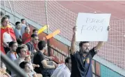  ?? AP ?? A man displays a banner that reads “Pique Out”, referring to Spain’s player Gerard Pique, before a training session in Madrid.