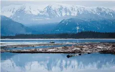  ?? DARRYL DYCK/THE CANADIAN PRESS ?? A small boat moves logs on the Douglas Channel at Kitimat, B.C. where the proposed Northern Gateway Project oil pipeline is to terminate.