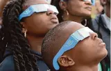  ?? Kirk Sides/Staff photograph­er ?? Leila and Gabriel Davis view the solar eclipse with their family at Space Center Houston.