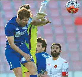  ??  ?? Valletta goalkeeper Dziukas Bartkus (in yellow) gets entangled in this aerial challenge with Daniel Ponce De Leon Garcia of Tarxien Rainbows (L) Photo: Domenic Aquilina