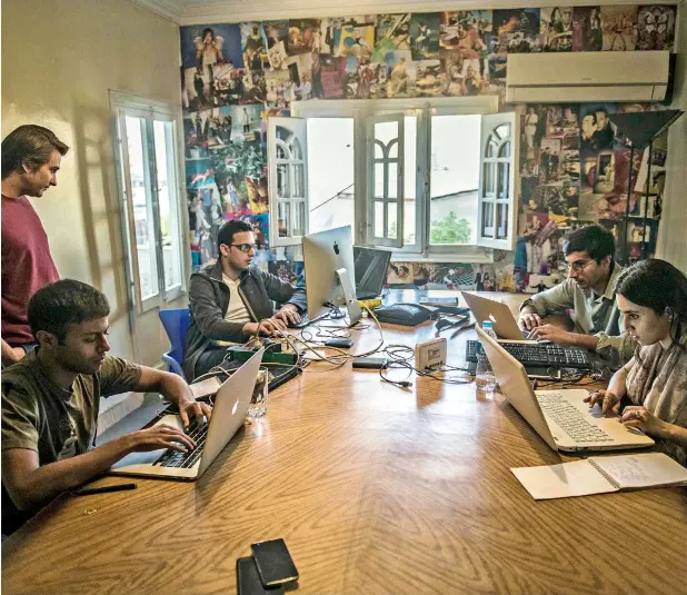  ?? —AFP File ?? Menna Ayman, Salem Massalha, Shehab Al Dien, Alban Menonville, and Nader Meleika, members of Bassita, the Egyptian start-up business, work at their office in Cairo. Bassita, which means “simple” in Arabic, is harnessing the growing Internet penetratio­n in the country and raising funds through social networking campaigns.