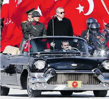  ?? ADEM ALTAN/AFP/GETTY IMAGES ?? Turkish President Recep Tayyip Erdogan, standing at right, and Chief of the General Staff of the Turkish Armed Forces Hulusi Akar are driven in a ceremony Thursday in Ankara marking the 92nd anniversar­y of Republic Day. Parliament­ary elections on Sunday are seen as a referendum on Erdogan’s 13 years in power.