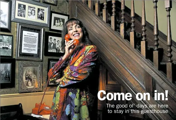  ??  ?? Melanie Patterson, owner of the Good Ol' Days House, poses with an old telephone in the front hall of the 1920s house her grandparen­ts bought in 1949.