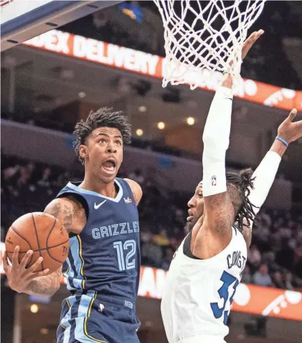  ?? ARIEL COBBERT/THE COMMERCIAL APPEAL ?? Memphis Grizzlies guard Ja Morant (12) shoots the ball over Minnesota Timberwolv­es guard Robert Covington during a game at the Fedexforum on Wednesday, Nov. 6, 2019.