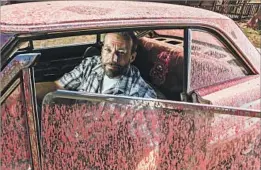 ??  ?? SABLE RANCH owner Derek Hunt sits in an old car that was splattered with fire retardant as the Sand fire tore through the 450-acre property.