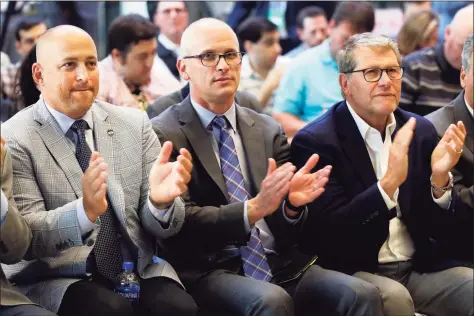  ?? Associated Press file photo ?? UConn Director of Athletics David Benedict, left, men's basketball coach Dan Hurley, center, and women’s basketball coach Geno Auriemma applaud during the announceme­nt that the University of Connecticu­t is re-joining the Big East Conference, at New York’s Madison Square Garden, in June 2019.