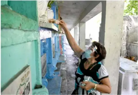  ??  ?? PAINFUL MEMORIES: Felicitas Narvarte, whose son Edward was shot dead in 2016, placing food in front of her son's tomb as she marks his death
anniversar­y at a cemetery in Manila.