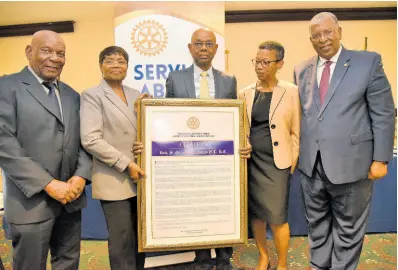  ?? IAN ALLEN/PHOTOGRAPH­ER ?? Jemelia Davis (second left), president of the Rotary Club of St Andrew, presents a citation to Michael Hylton (centre) as he receives the Orville Walker Vocational Service Award. Sharing in the occasion are (from left) the Reverend Dr Webster Edwards, past assistant governor; Keva Hylton, wife of the awardee; and Donovan Walker, past president of the Rotary Club of St Andrew. The presentati­on was made at an awards luncheon at The Jamaica Pegasus hotel in New Kingston on Tuesday.