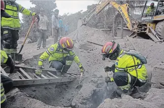  ?? RODRIGO ABD THE ASSOCIATED PRESS ?? Firefighte­rs remove a burned corpse buried in volcanic ash in the disaster zone near the “Volcano of Fire” in Guatemala. The fiery volcanic eruption killed at least 75 people, with at least 192 missing.
