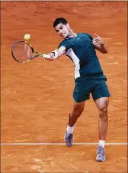  ?? Clive Brunskill / Getty Images ?? Carlos Alcaraz plays a forehand against Novak Djokovic in the semifinals of the Madrid Open on May 7.