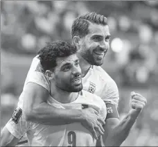  ?? AP ?? Iran’s Mehdi Taremi (left) and Karim Ansarifard are all smiles after beating Wales at the World Cup in Qatar on Nov 25.