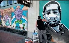 ?? JANE TYSKA — STAFF PHOTOGRAPH­ER ?? Ethan Martinez, of Hayward, works on a mural of George Floyd on Broadway in downtown Oakland on Monday.
