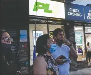  ??  ?? Magnolia Ortega (center) stands outside a Western Union with her husband Arturo Morales and their daughter Marlene after wiring money to her family in Mexico in Staten Island. (AP/John Minchillo)