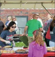  ?? KRISTI GARABRANDT — THE NEWS-HERALD ?? Compliment­ary hot dogs, chips and desserts are served to community members who attended the Later Gator Bash on May 4.