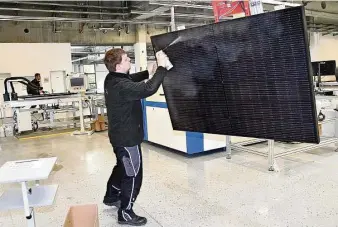  ?? Foto: Marion Doering ?? Operator und Schichtlei­ter Christoph Thime beim Säubern eines PVT-Moduls der Firma Sunmaxx, das eine Symbiose aus Strom- und Wärmeerzeu­gung bietet.