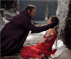  ??  ?? Hugh Jackman as Jean Valjean, left, and Anne Hathaway as Fantine are shown in a scene from “Les Miserables.”
