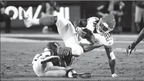  ?? USA TODAY SPORTS ?? Kansas City Chiefs running back Kareem Hunt is upended by Los Angeles Rams inside linebacker Cory Littleton during Monday’s NFL game in LA. The Rams won 54-51 — the first time in NFL history both teams have scored over 50 points, while their combined 105 is a Monday Night Football record, spanning 773 games.