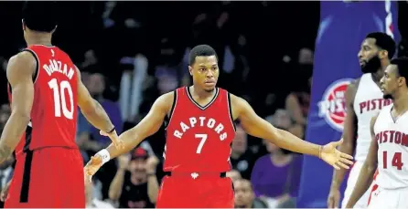  ?? GREGORY SHAMUS/GETTY IMAGES ?? Kyle Lowry (centre) celebrates a second-half basket with DeMar DeRozan (left) while playing the Detroit Pistons on Wednesday.