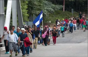  ?? AP PHOTO/ MOISES CASTILLO ?? Honduran migrants walk toward the U.S. as they make their way through Chiquimula, Guatemala, Oct. 16. U.S. President Donald Trump threatened on Tuesday to cut aid to Honduras if it doesn't stop the impromptu caravan of migrants, but it remains unclear if government­s in the region can summon the political will to physically halt the determined bordercros­sers.