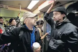  ??  ?? ANDREW TISBERT, an outreach specialist with PATH, talks to Anthonie Johnson, a 54-year-old homeless Navy veteran, on a Red Line train Wednesday.