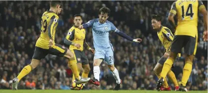  ?? — AP ?? MANCHESTER: Manchester City’s David Silva is surrounded by Arsenal players during the English Premier League soccer match between Manchester City and Arsenal at the Etihad Stadium in Manchester, England, yesterday.