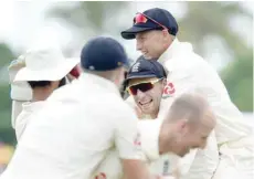  ?? — AFP ?? England’s captain Joe Root (centre) and Jos Buttler (top centre) celebrate with team-mates after dismissing Sri Lanka’s Kusal Mendis at the Galle Internatio­nal Cricket Stadium in Galle.