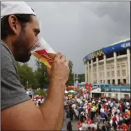  ?? ?? A man drinks a beer in a Budweiser pavilion in front of Luzhniki Stadium as fans arrive for the semifinal match between Croatia and England during the 2018 soccer World Cup in Moscow. The sale of all alcoholic beer at the eight World Cup stadiums in Qatar was banned Friday just two days before the tournament’s first match.