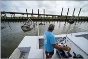  ?? GERALD HERBERT — THE ASSOCIATED PRESS ?? Frank Jurisich motors past shrimp boats that caught fire and burned during Hurricane Ida, as he and his brother go check on their oyster beds in Plaquemine­s Parish, La.