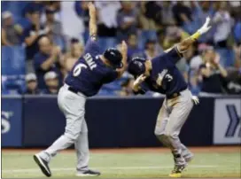  ?? CHRIS O’MEARA — THE ASSOCIATED PRESS ?? Milwaukee’s Orlando Arcia (3) celebrates with third base coach Ed Sedar (6) after Arcia hit a home run off Tampa Bay’s Sergio Romo during the eighth inning Friday in St. Petersburg, Fla.