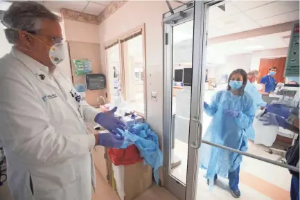  ?? JOE RONDONE/THE COMMERCIAL APPEAL ?? Dr. Steve Threlkeld, co-chair of the infection control program at Baptist Memorial Hospital-memphis, prepares to remove his protective gear after checking on a patient with COVID-19 at the hospital on May 14.