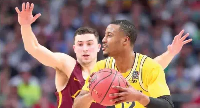  ?? TOM PENNINGTON/ GETTY IMAGES ?? Loyola’s Ben Richardson defends against Michigan’s Muhammad- Ali Abdur- Rahkman in the first half.