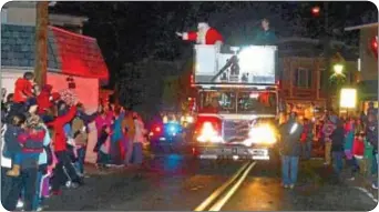  ?? Photo by Jeff Goldberg ?? Santa Claus arrives at the tree lighting ceremony aboard Yardley-Makefield Fire Company Tower 80.