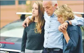  ?? Josh Edelson Associated Press ?? RELATIVES of Finnegan Elder, 19, embrace outside their home while their attorney speaks to reporters. Authoritie­s in Rome say Elder stabbed a police officer.