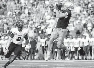  ?? MICHAEL HICKEY/GETTY ?? Notre Dame tight end Michael Mayer, right, goes up to haul in the game-winning touchdown behind Toledo’s Dyontae Johnson late in the fourth quarter Saturday in South Bend, Ind.