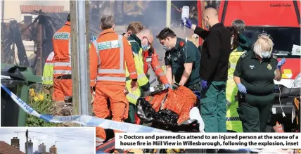  ?? Gareth Fuller ?? > Doctors and paramedics attend to an injured person at the scene of a house fire in Mill View in Willesboro­ugh, following the explosion, inset