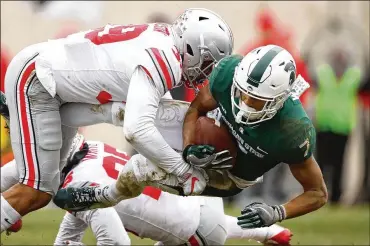  ?? GREGORY SHAMUS / GETTY IMAGES ?? Buckeyes linebacker Malik Harrison takes down Spartans wide receiver Cody White on Saturday during Ohio State’s 26-6 win.
