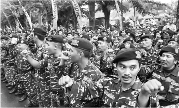  ?? — AFP photo ?? File photo taken on Feb 3 shows members of the Banser Gerakan Pemuda Ansor, a paramilita­ry wing of Indonesia’s biggest Muslim organisati­on Nahdatul Ulama (NU), during a roll call in Sidoarjo.